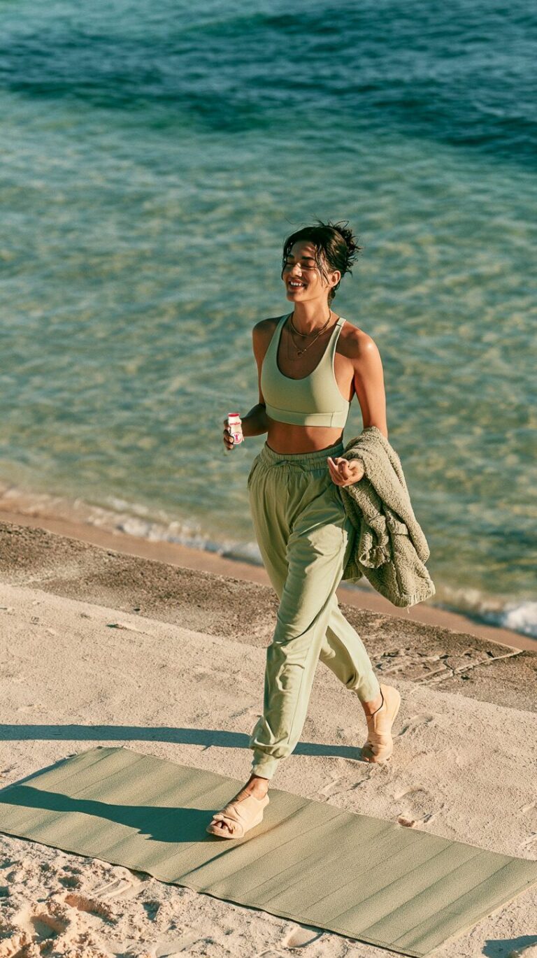 Woman walking by the water on a bright morning with a ProLive bottle